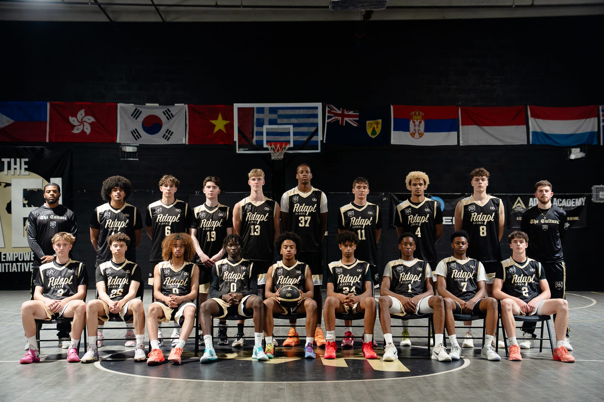 Academy players in black jerseys lined up for a team photo on the DETAIL Miami court