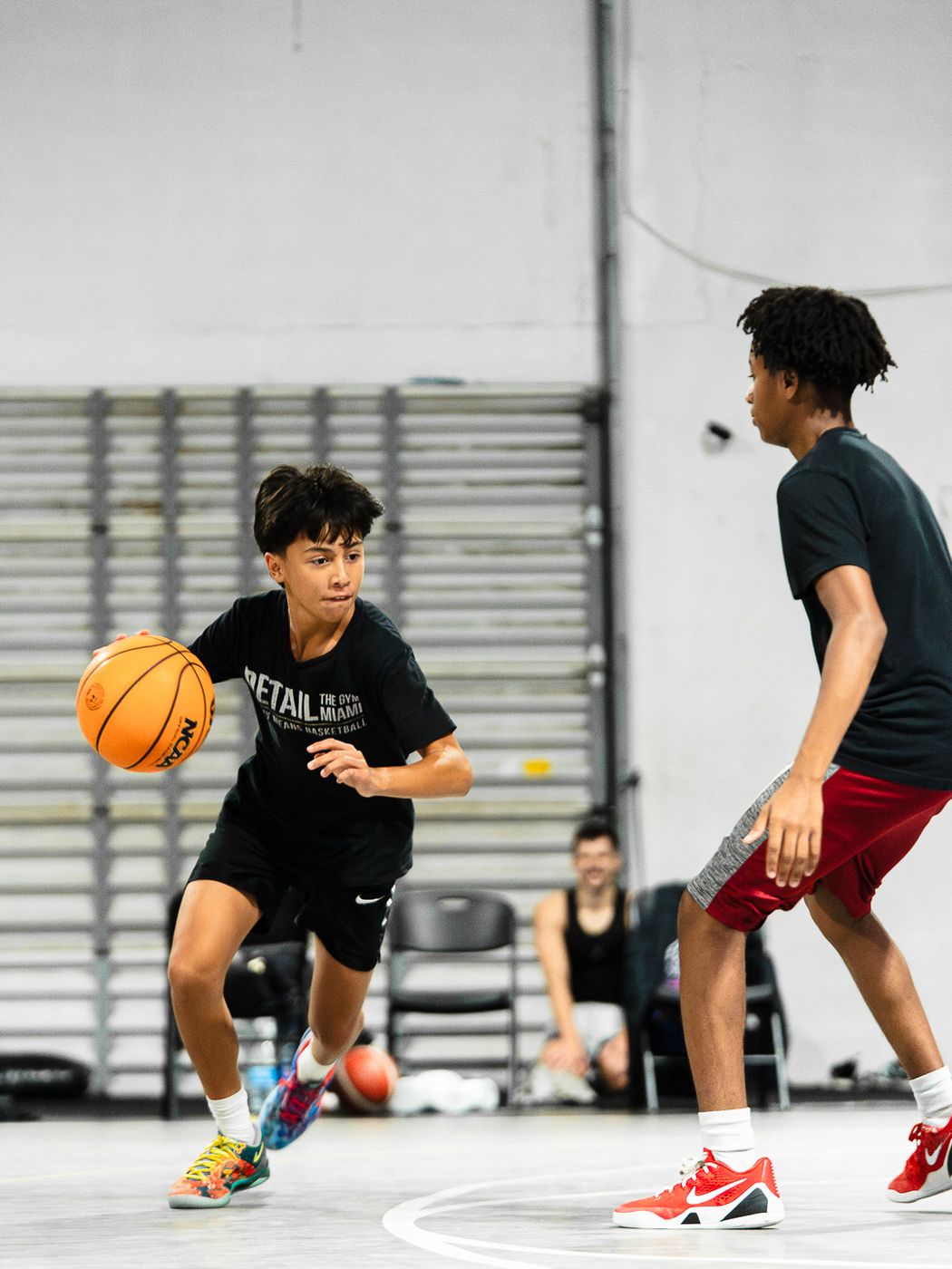 Young player in a DETAIL shirt dribbling at a defender during live play at DETAIL Miami