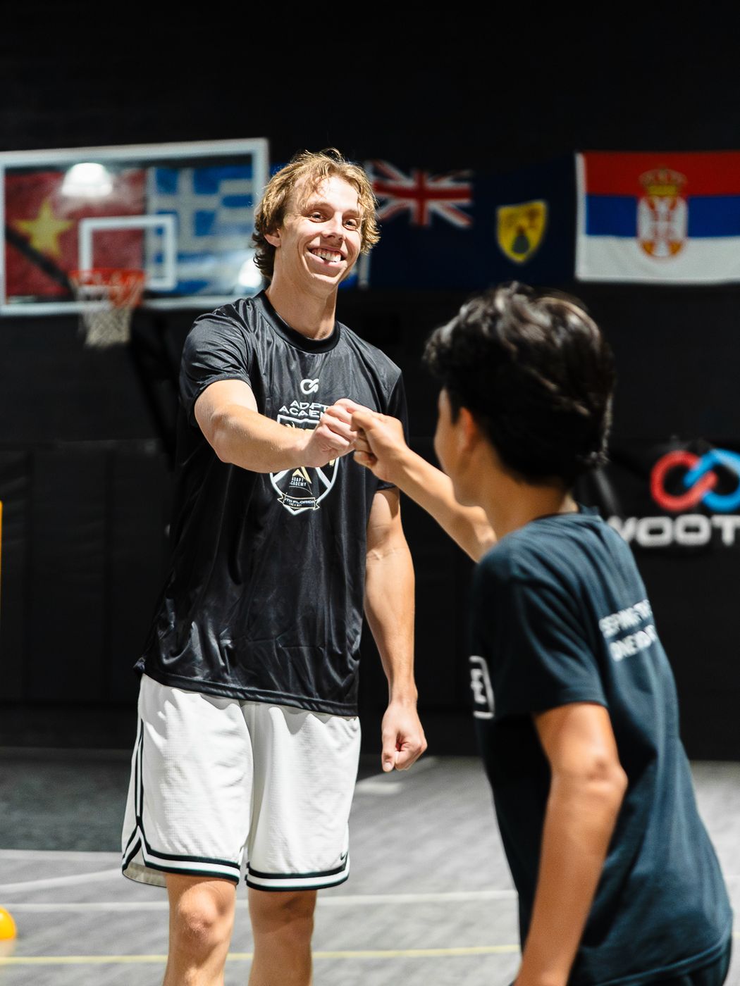 DETAIL Miami coach smiling and bumping fists with a young player on the court